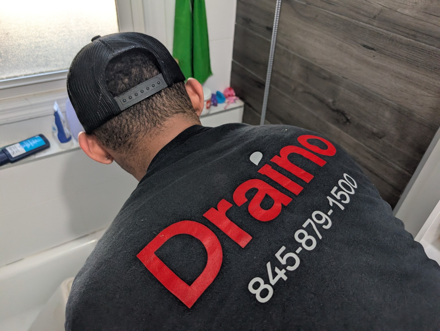 Draino technician working by a tub
