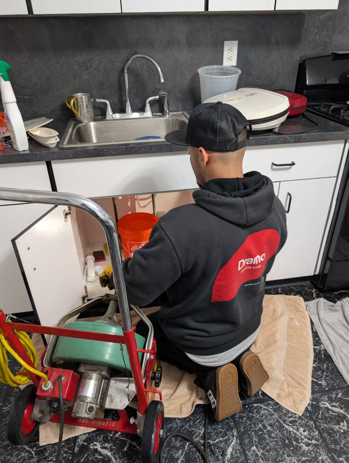 Draino technician clearing a kitchen drain