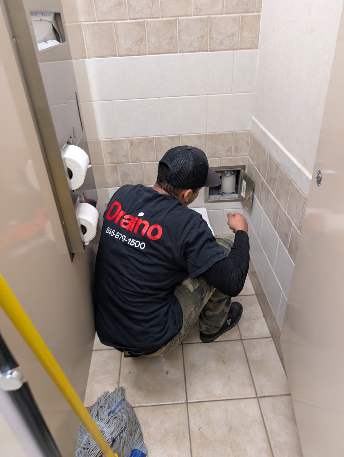 Draino technician working in a restroom