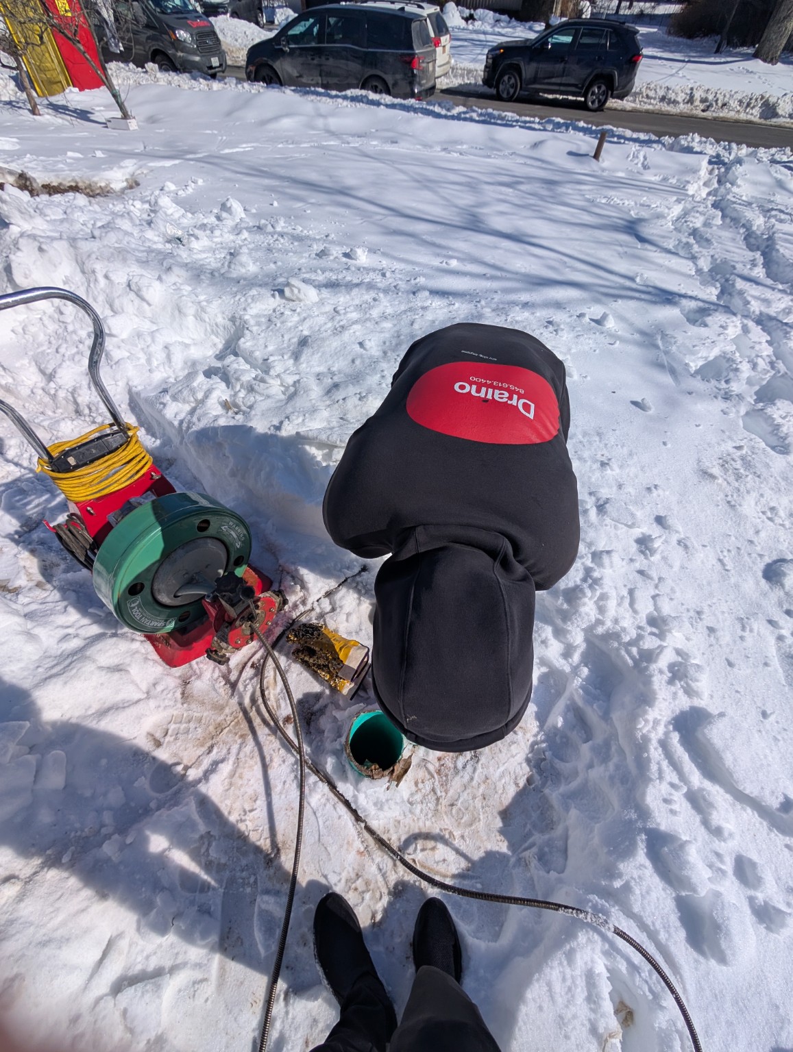 Draino technician working on a sewer line in winter